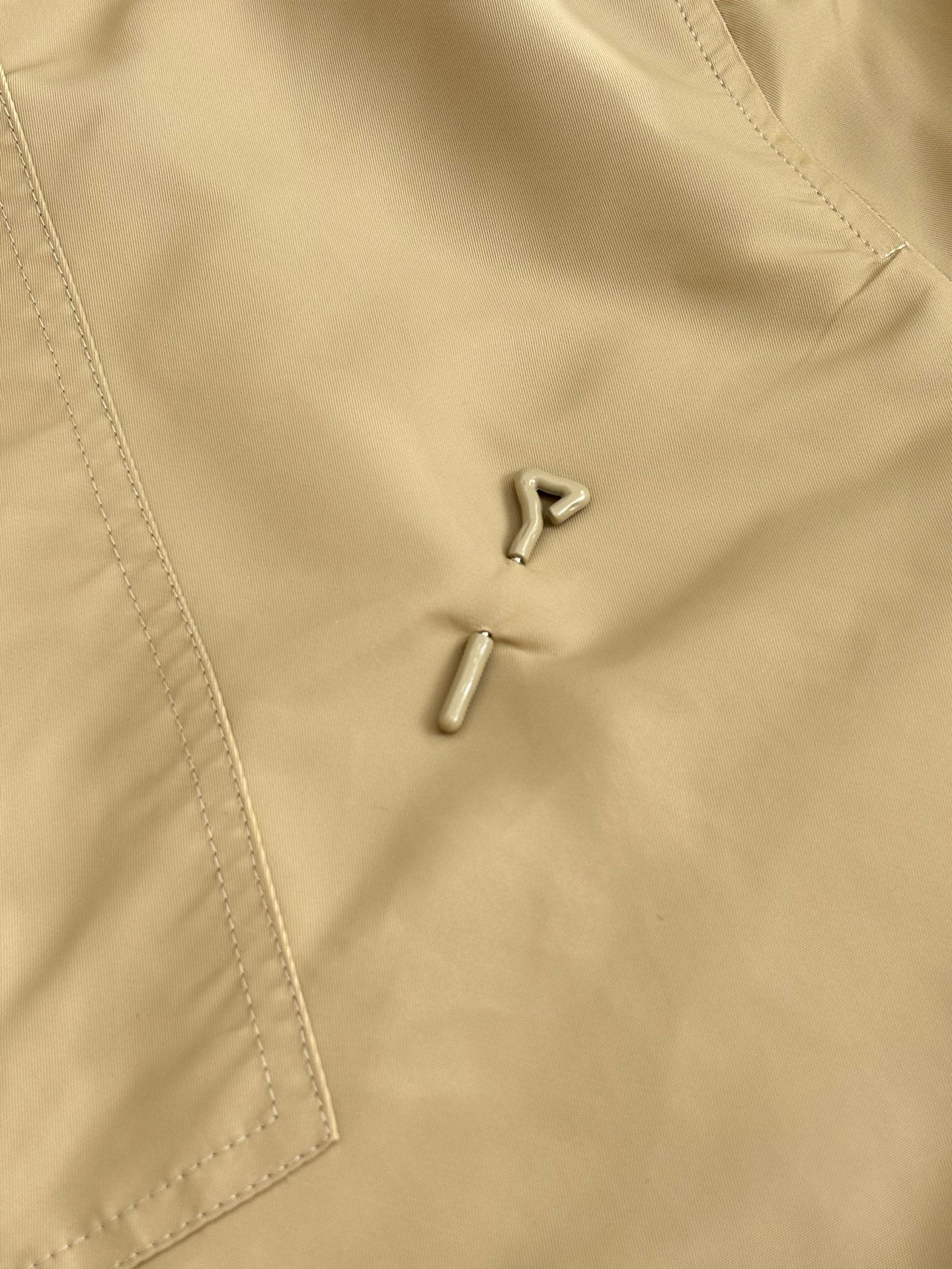 Beige long pants, close-up of zipper and metal snap at front