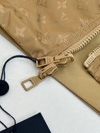 Louis Vuitton jacket detail, tan monogram with zip pull and label loop