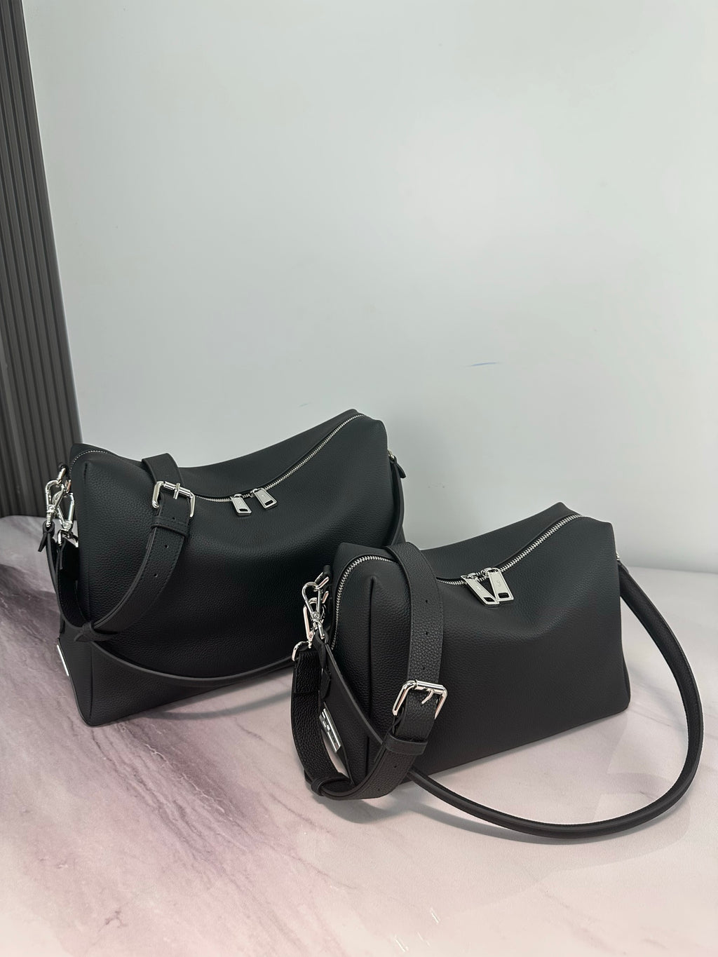 Two Fendi dark leather bags with straps, including a hobo style and mini crossbody