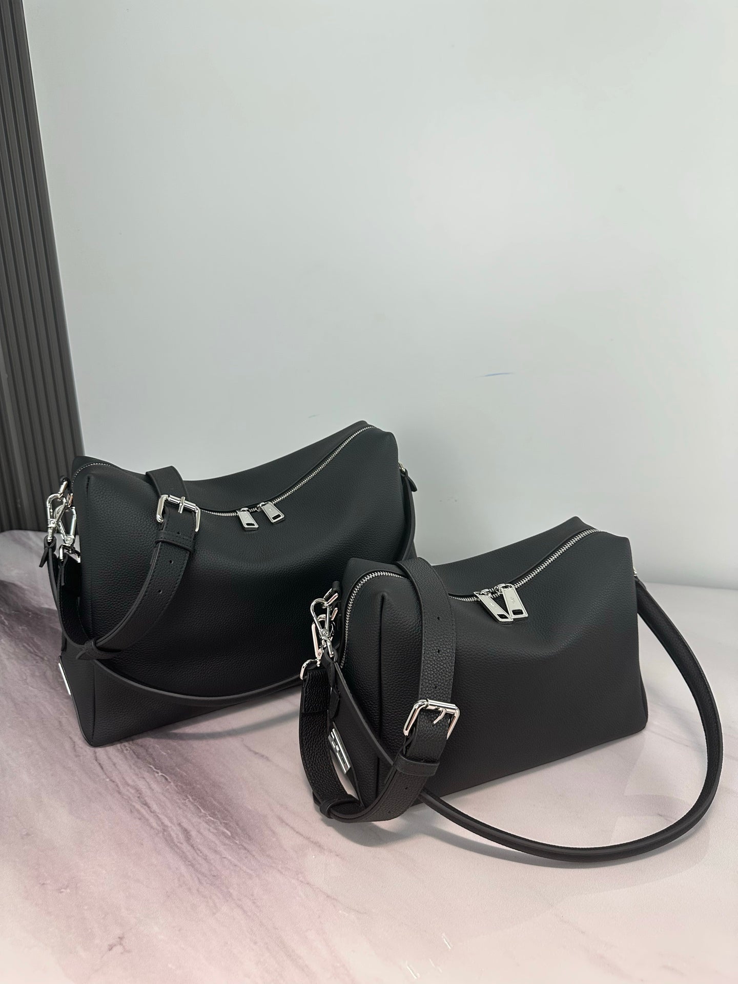 Two Fendi dark leather bags with straps, including a hobo style and mini crossbody