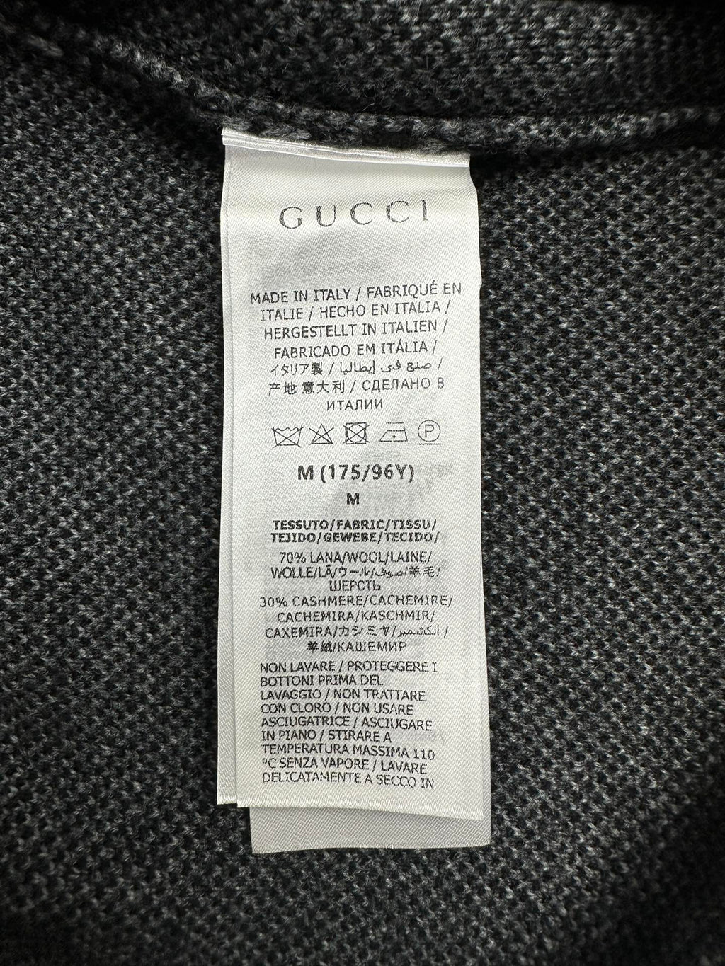 Gucci clothing care label on dark knit sweater