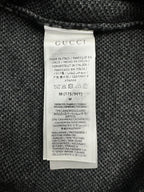 Gucci clothing care label on dark knit sweater