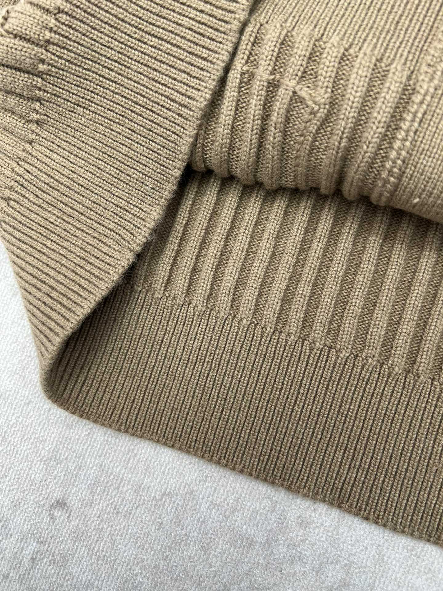 Beige rib-knit sweater hem with folded cuff and textured knit stripes