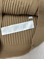 Beige rib-knit cardigan belt area with internal fabric tag label