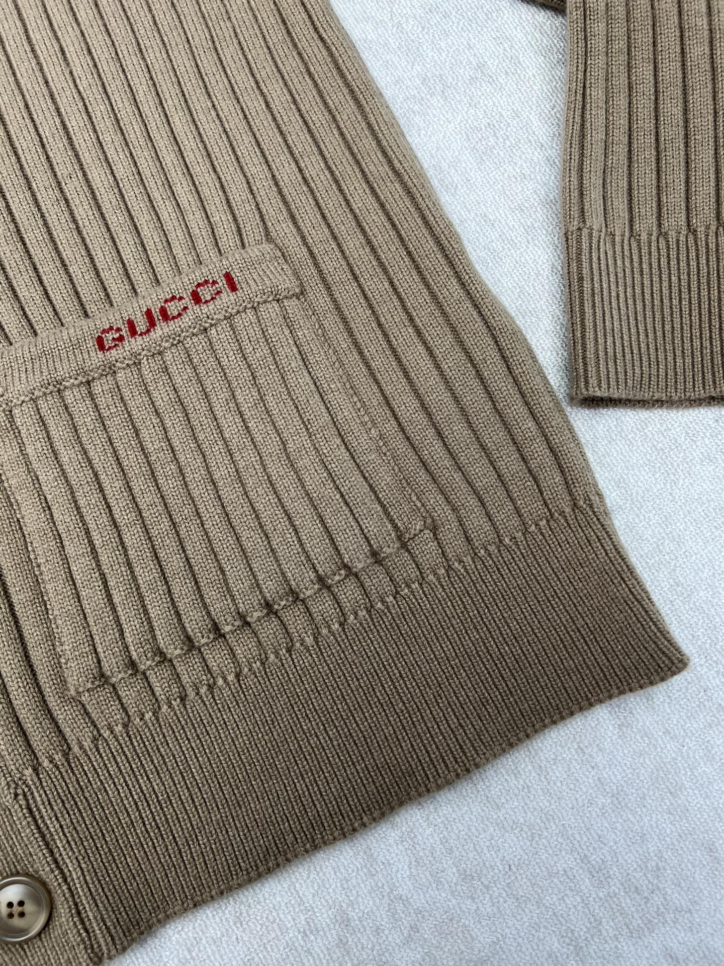 Beige rib-knit cardigan sleeve cuff with small Gucci logo patch