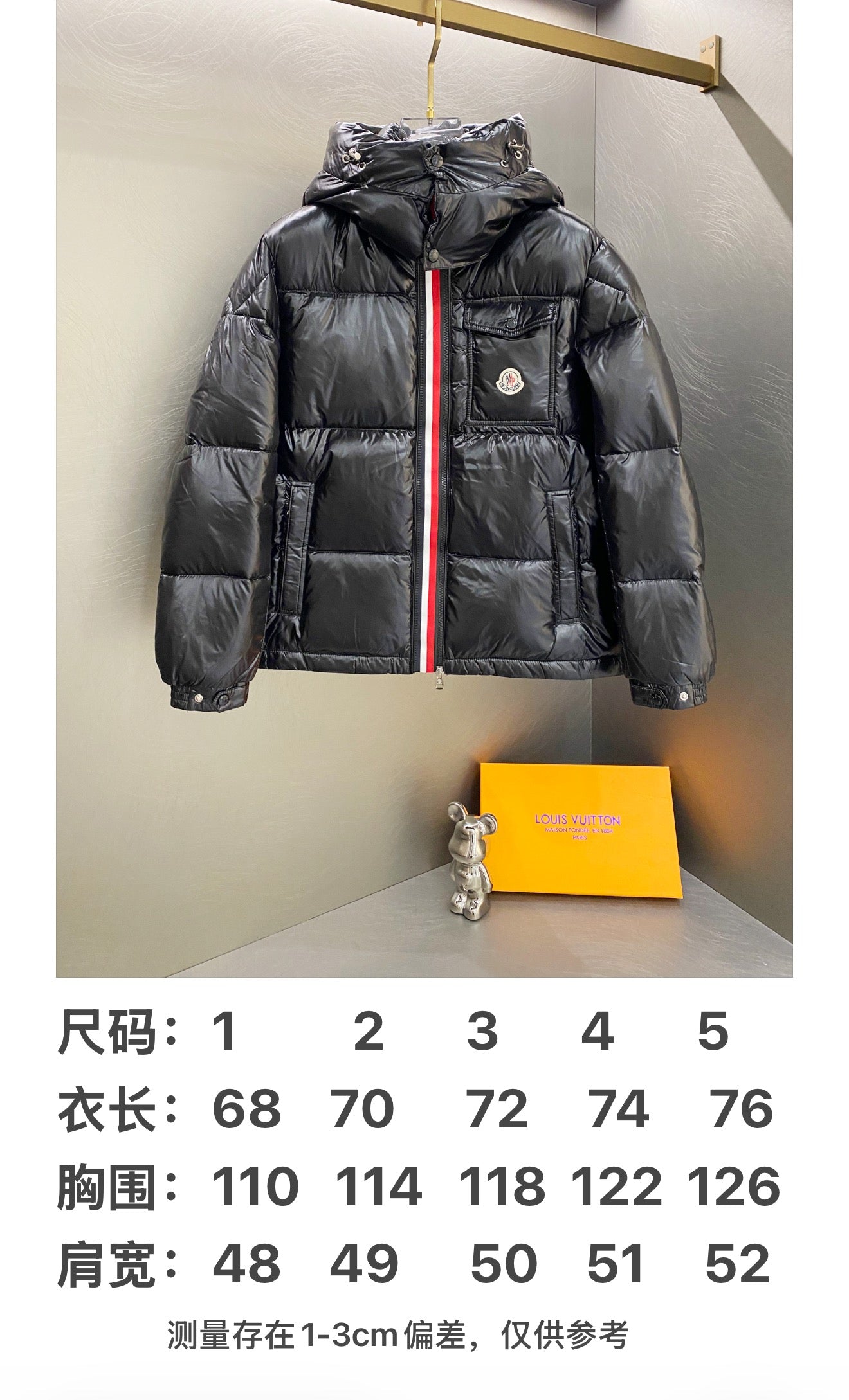 Moncler long padded jacket front view, dark hooded puffer with red center stripe