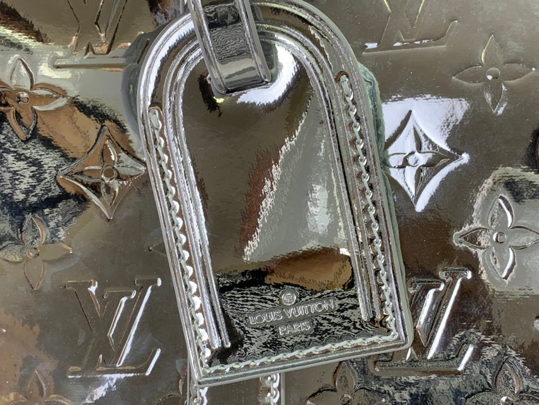 Louis Vuitton metallic silver bag handle and monogram pattern detail on leather trim
