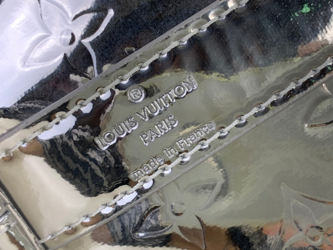 Louis Vuitton metallic silver interior lining detail with brand stamp and chain trim