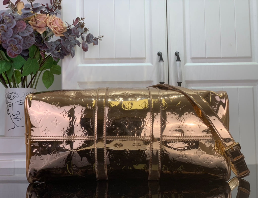 Gold monogram duffel bag with detachable shoulder strap and top handle, shiny