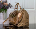 Brownish-gold monogram duffel bag with curved top handle and shoulder strap
