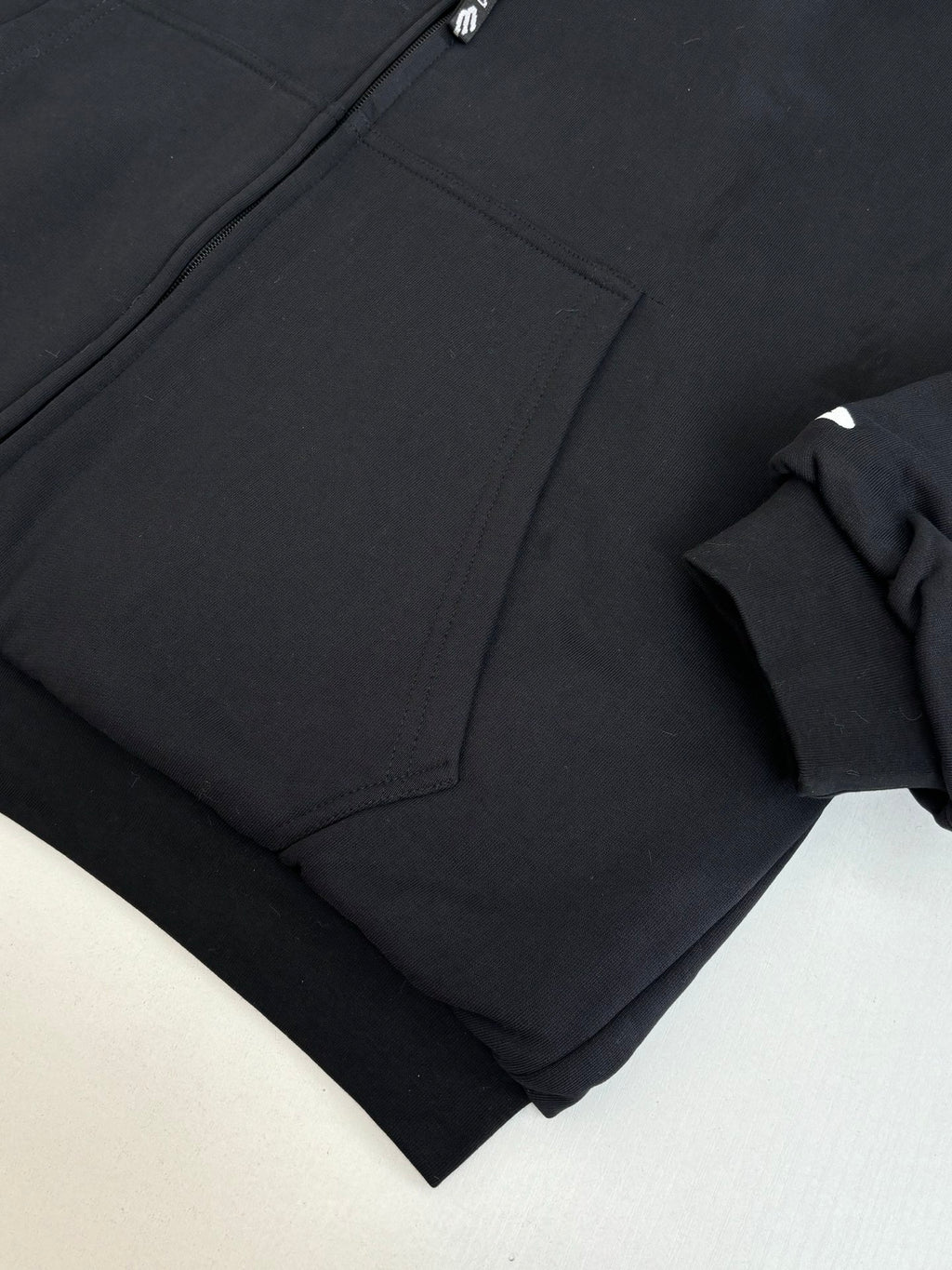 Zip-up jacket fabric close-up with angled seam and pocket panel