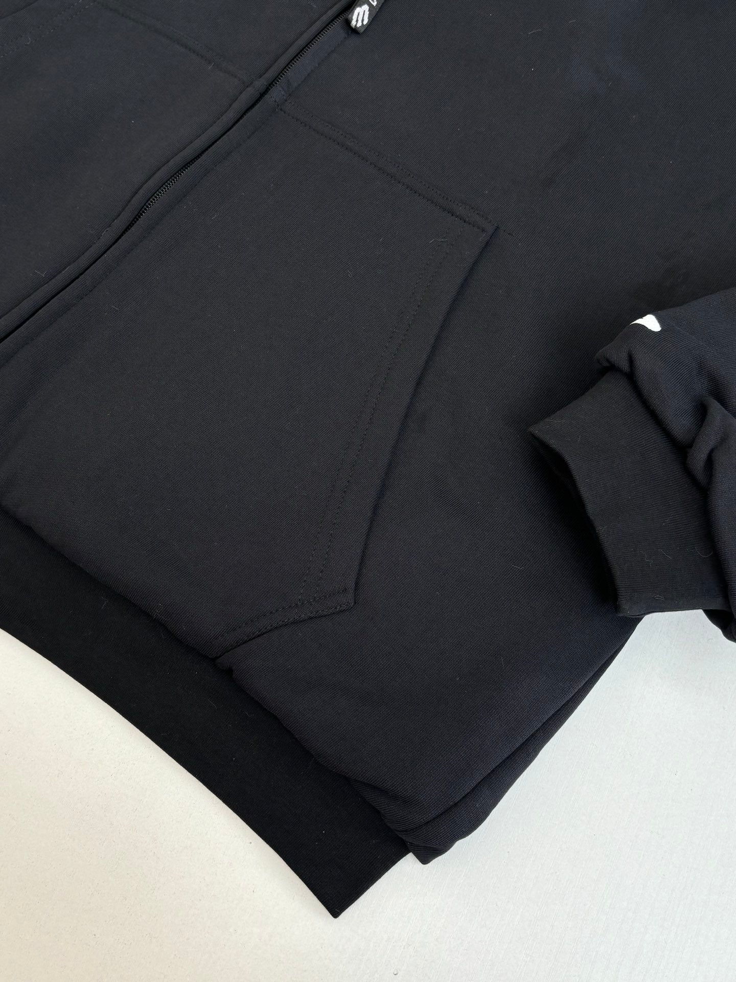 Zip-up jacket fabric close-up with angled seam and pocket panel