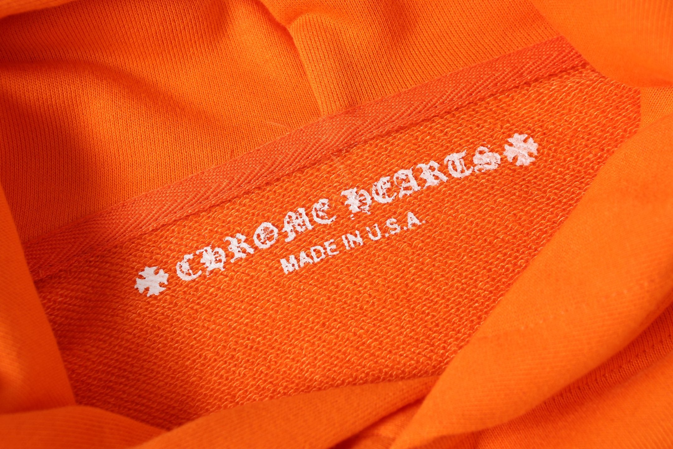 Orange hoodie fabric label text “Made in USA”