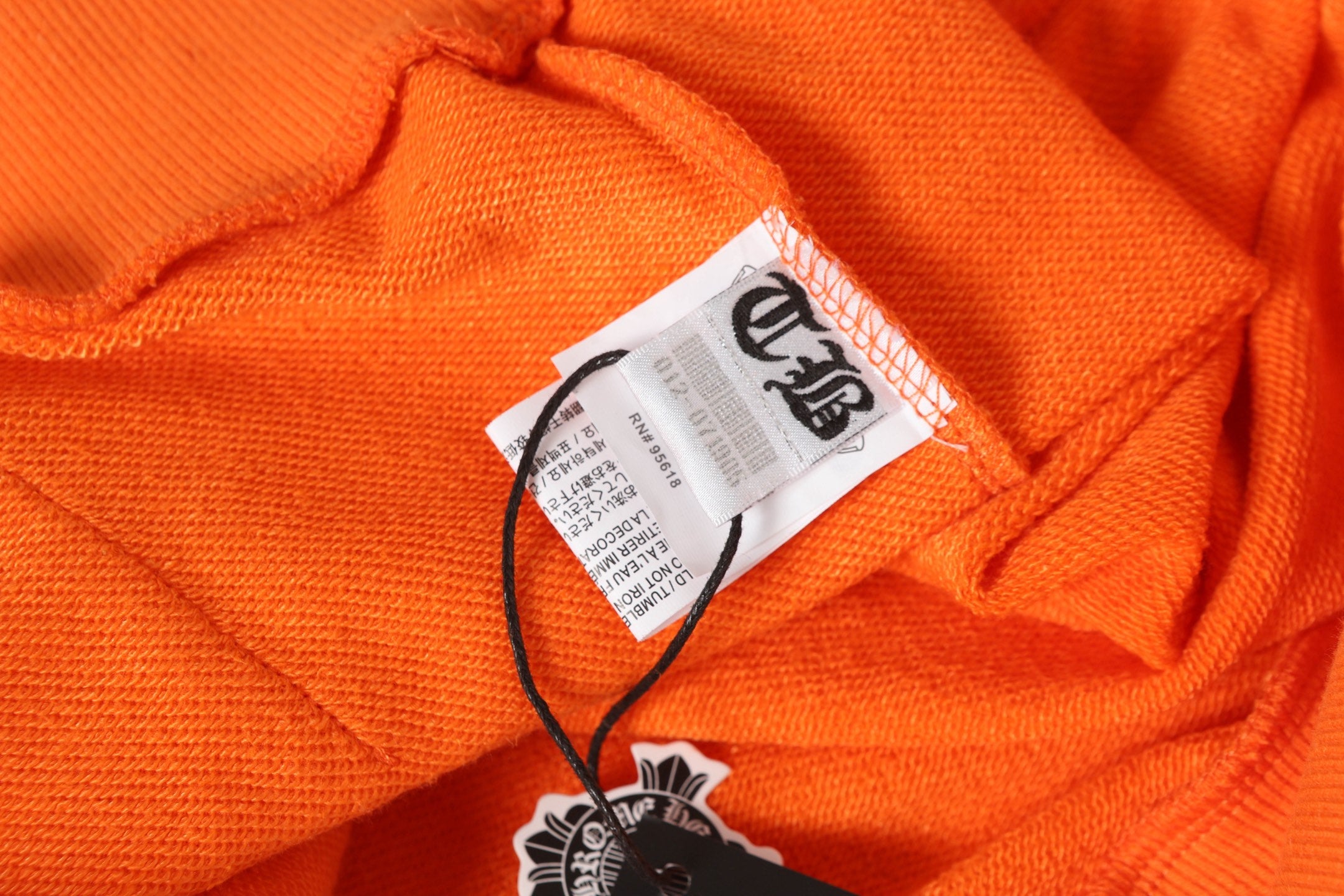 Orange long-sleeve shirt collar with attached white brand label