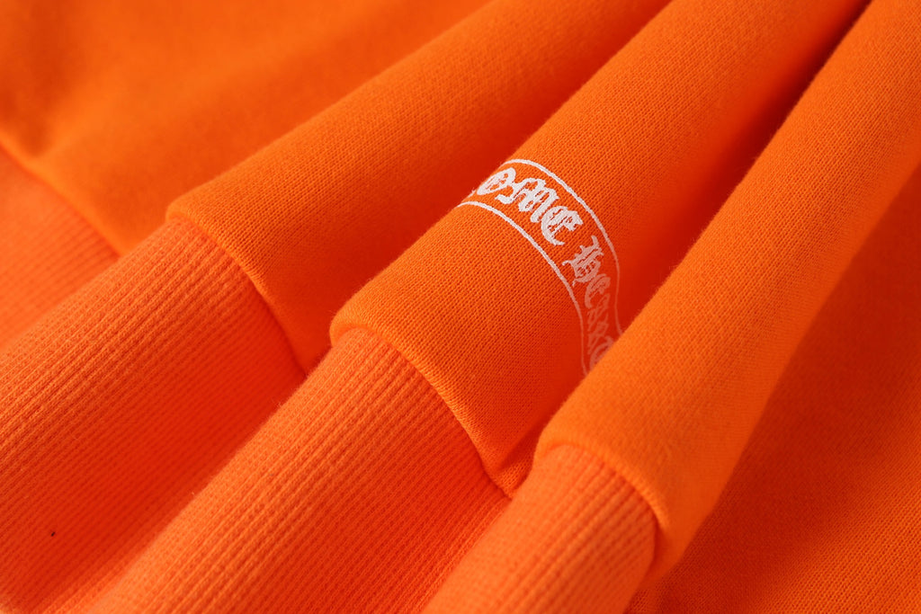 Orange long-sleeve shirt cuff with small embroidered logo