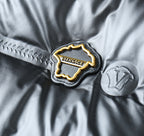 Embroidered Versace logo patch on black puffer jacket with gold trim