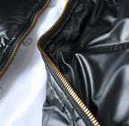 Black puffer jacket zipper seam with gold piping detail