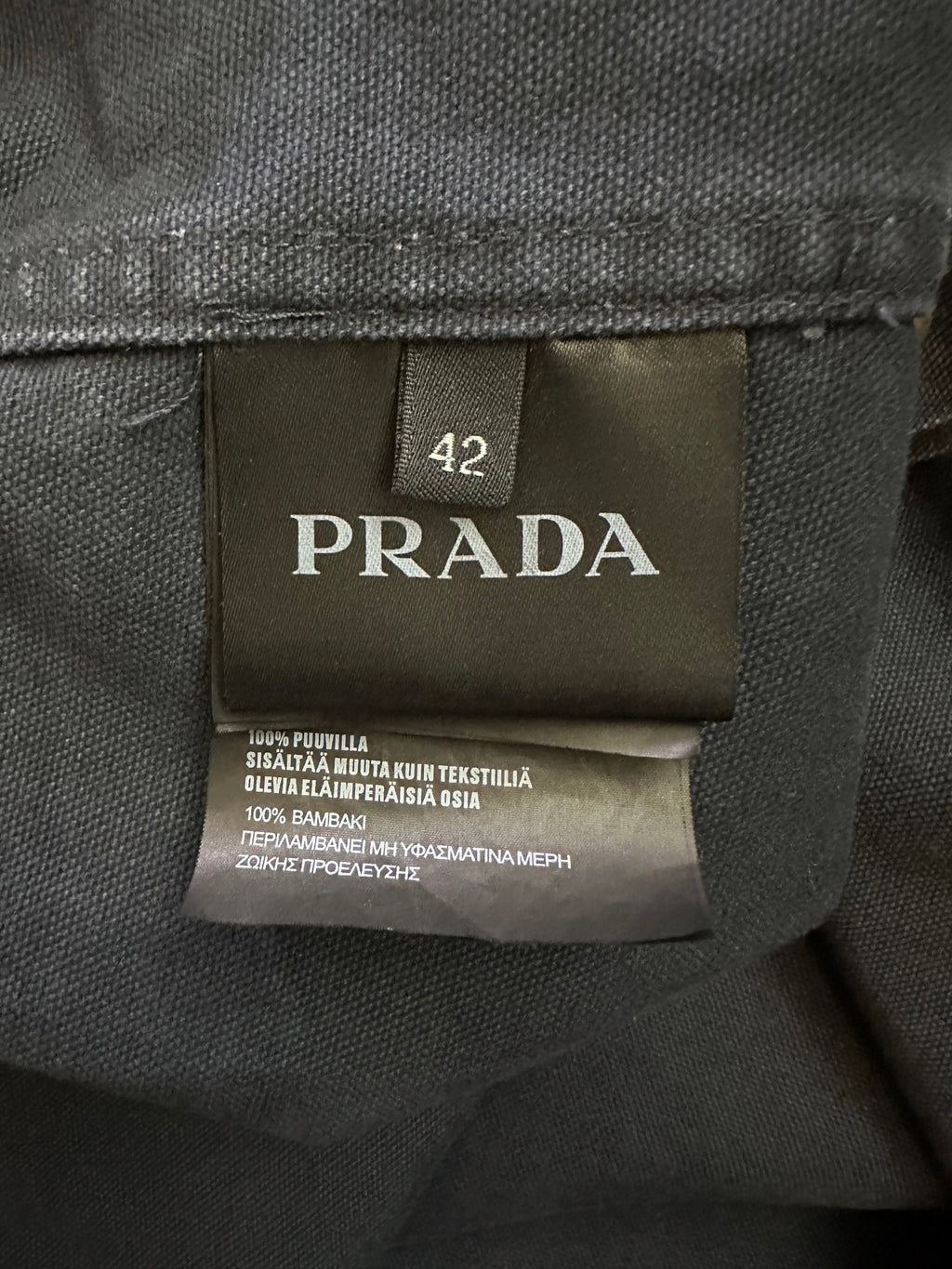 Size 42 fabric care label inside jacket on dark lining with printed text