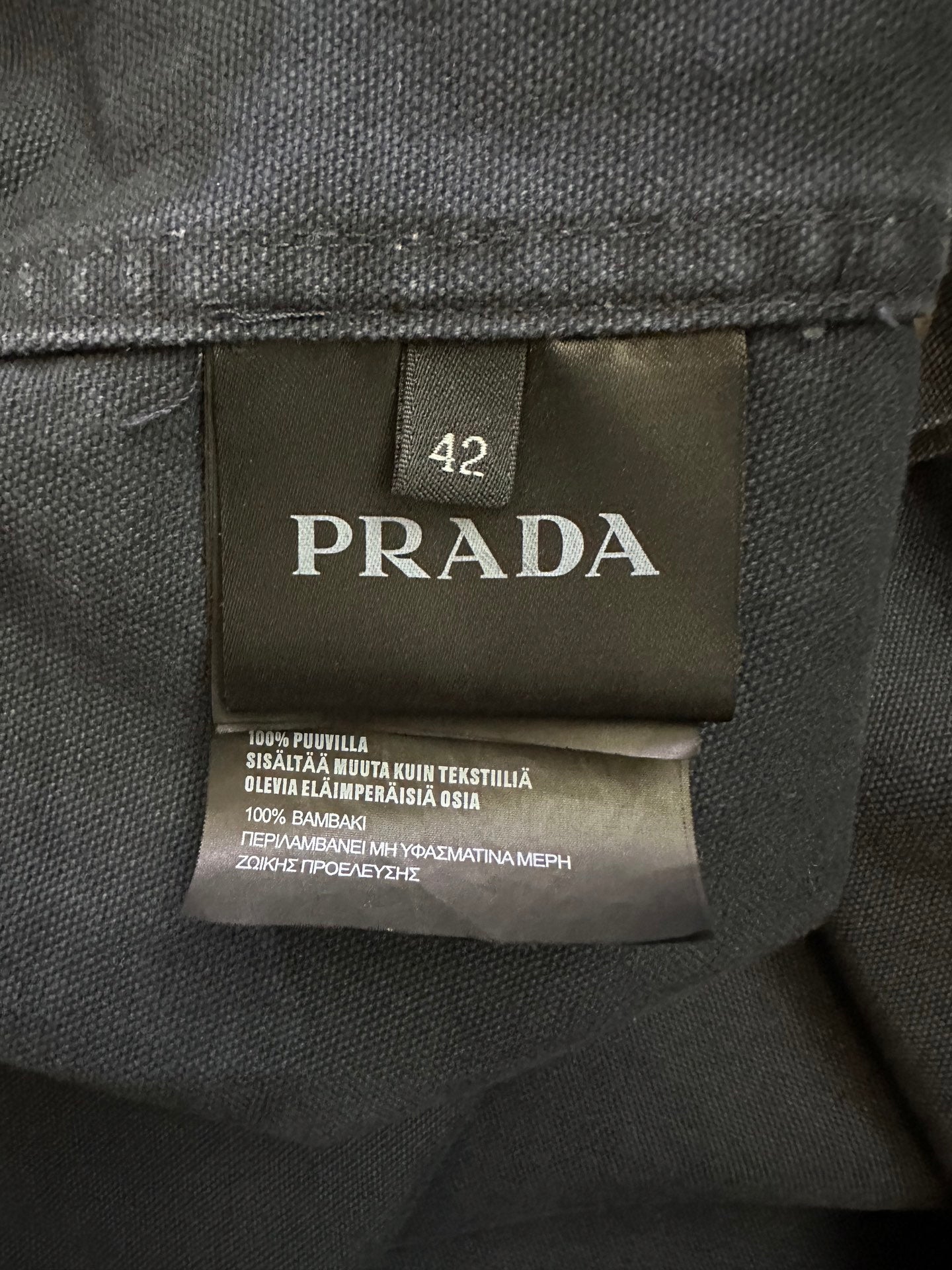 Size 42 fabric care label inside jacket on dark lining with printed text
