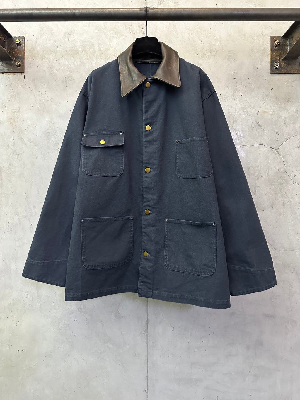 Navy long jacket with point collar, button front, and two flap chest pockets