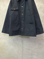 Navy long jacket with button front, flap chest pockets, and flap sleeve cuffs