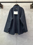 Navy long jacket with curved back hem, side vents, cuff flaps, and back hang tag