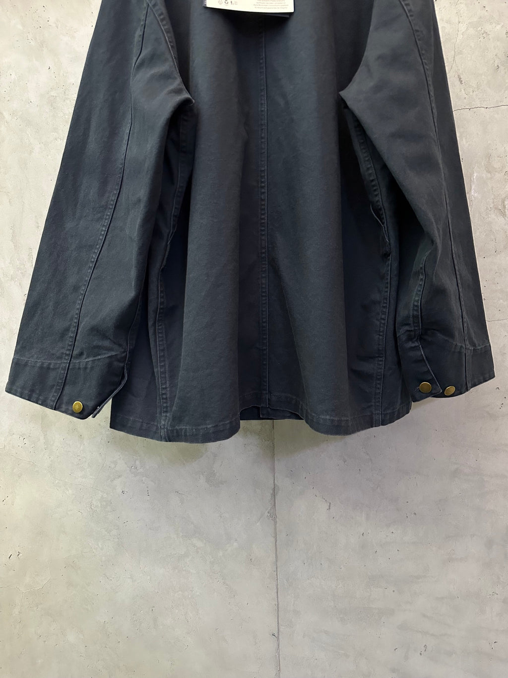 Navy long jacket interior view with pocket opening and buttoned cuffs