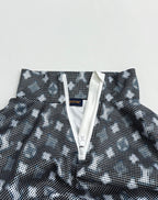 Long-sleeve top close-up of front placket with zipper pull and dark geometric print