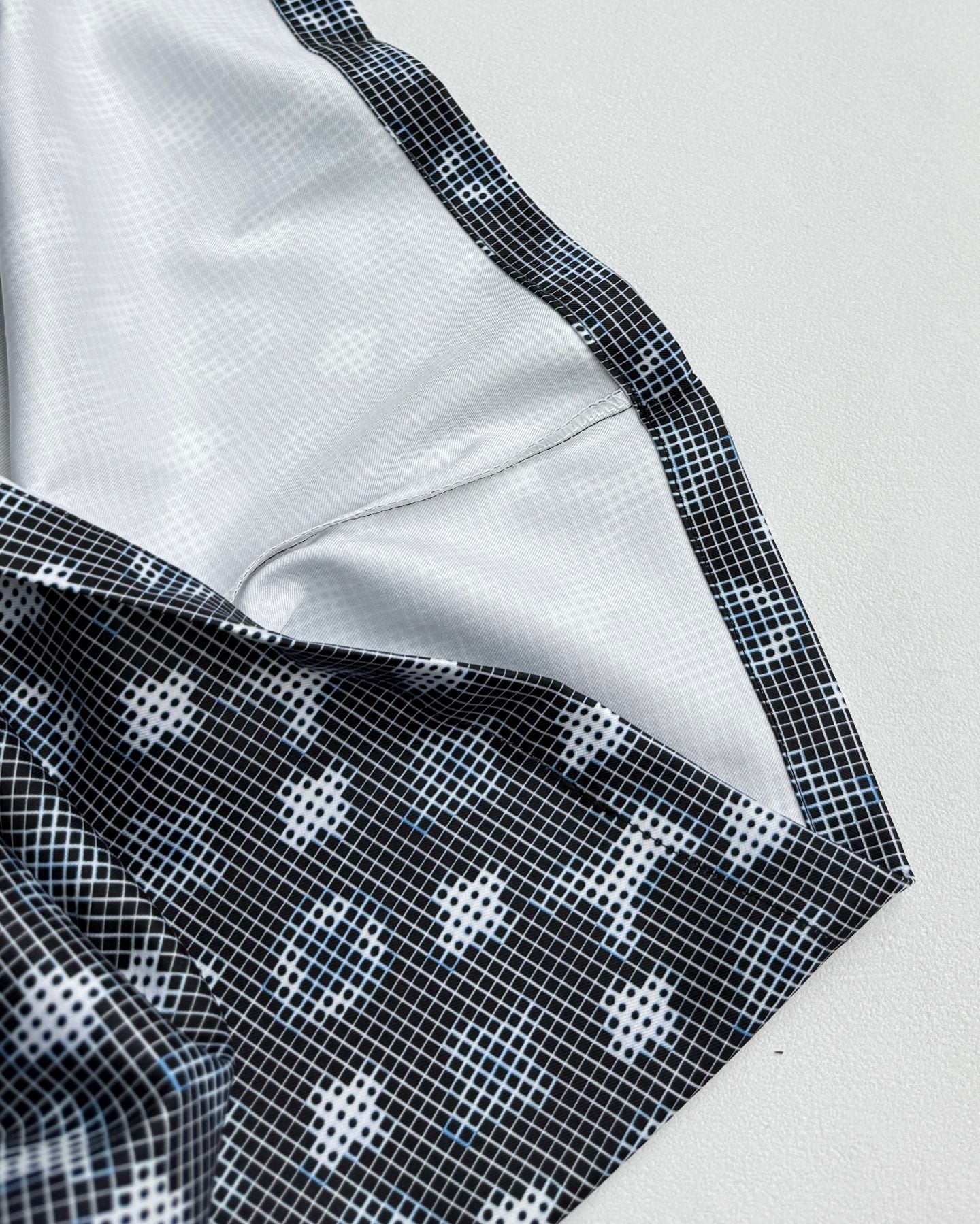 Long-sleeve top close-up of shoulder seam and contrast white trim with dark print