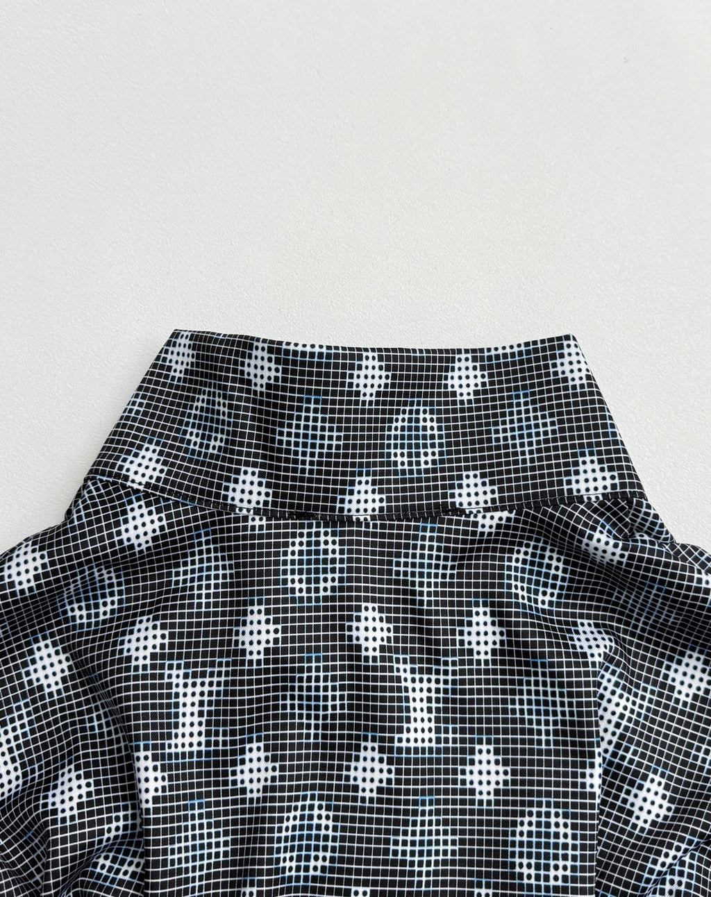 Long-sleeve top collar area with dark geometric pattern and wide neckline band
