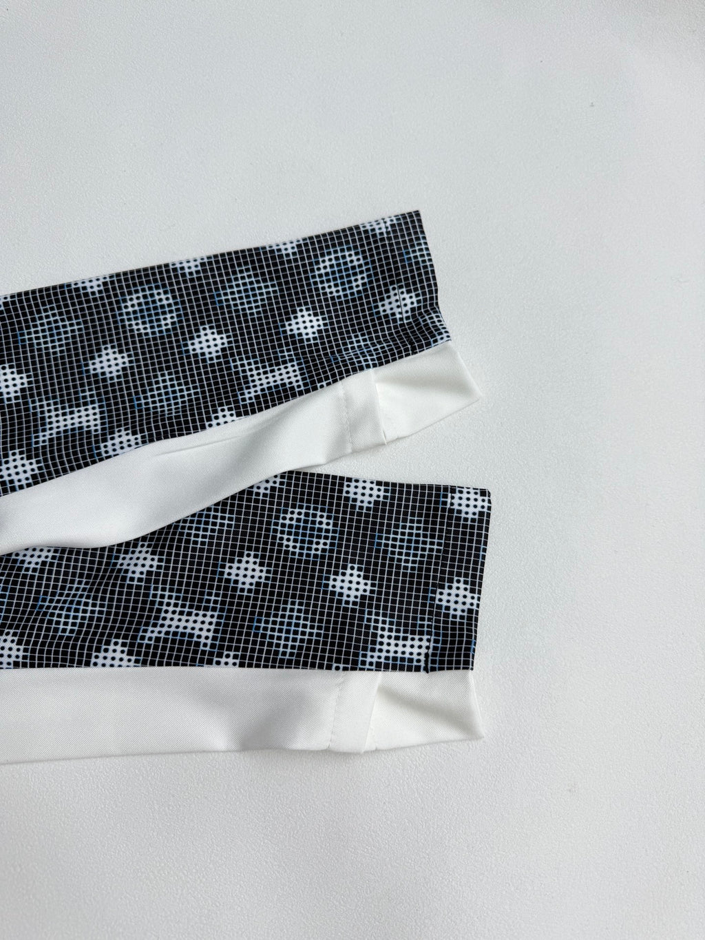 Long-sleeve top sleeve cuffs with white bands and dark geometric pattern