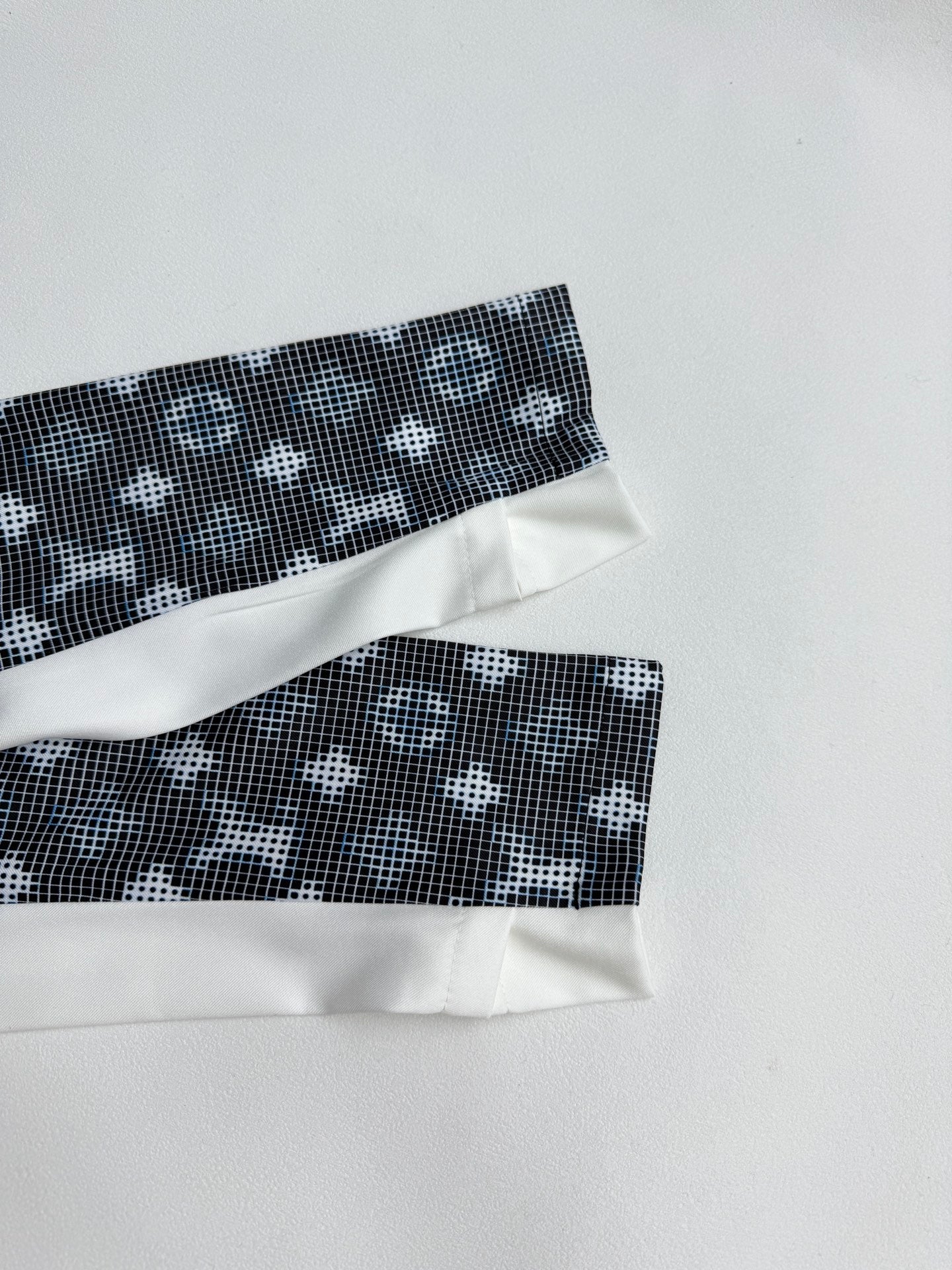 Long-sleeve top sleeve cuffs with white bands and dark geometric pattern