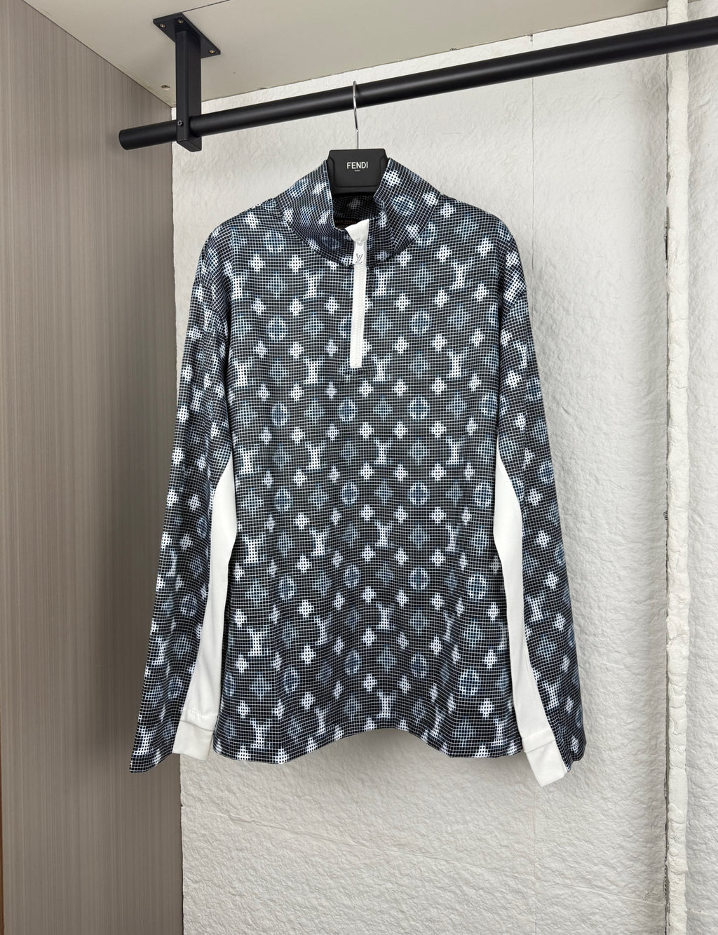 Long-sleeve top with dark geometric pattern, half-zip placket, and standing collar