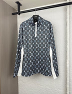 Long-sleeve top with dark geometric pattern, half-zip placket, and standing collar