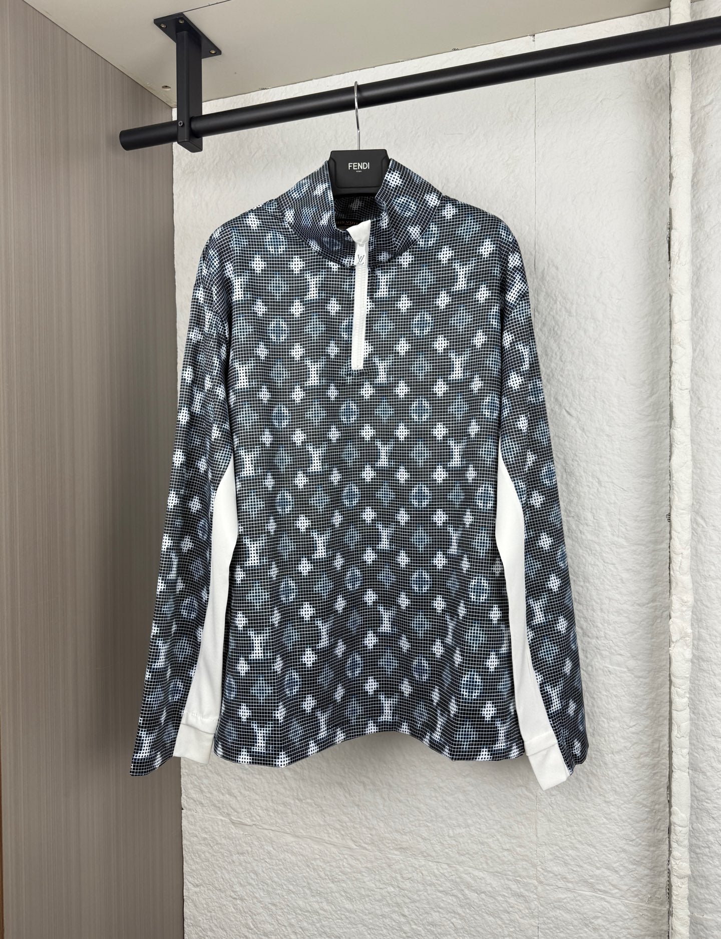 Long-sleeve top with dark geometric pattern, half-zip placket, and standing collar