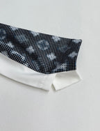 Long-sleeve cuff detail with dark geometric print and white band at the hem