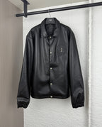 Black leather-look bomber jacket with snap front, stand collar and chest patch