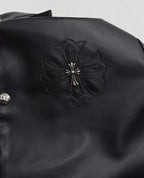 Black leather-look jacket with embroidered floral cross patch on shoulder