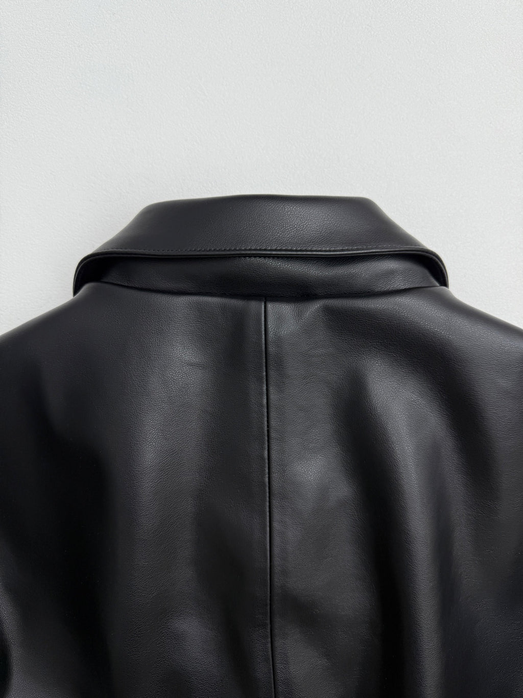 Black leather-look jacket with structured shoulder yoke and back collar