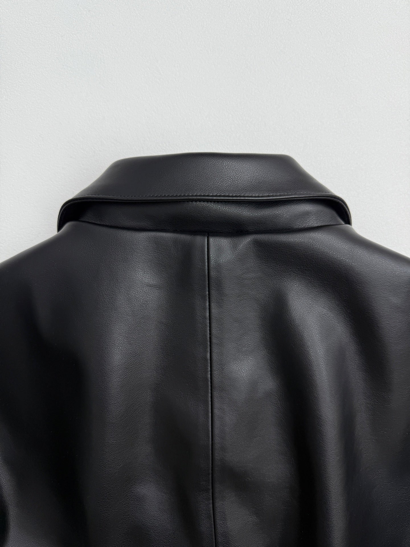 Black leather-look jacket with structured shoulder yoke and back collar
