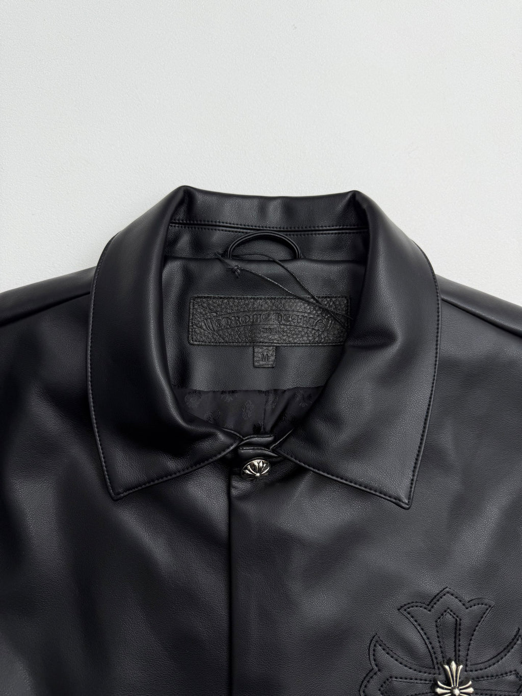 Black leather-look jacket collar with inner label and button placket