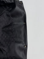 Black leather-look jacket front panel with dark snap buttons