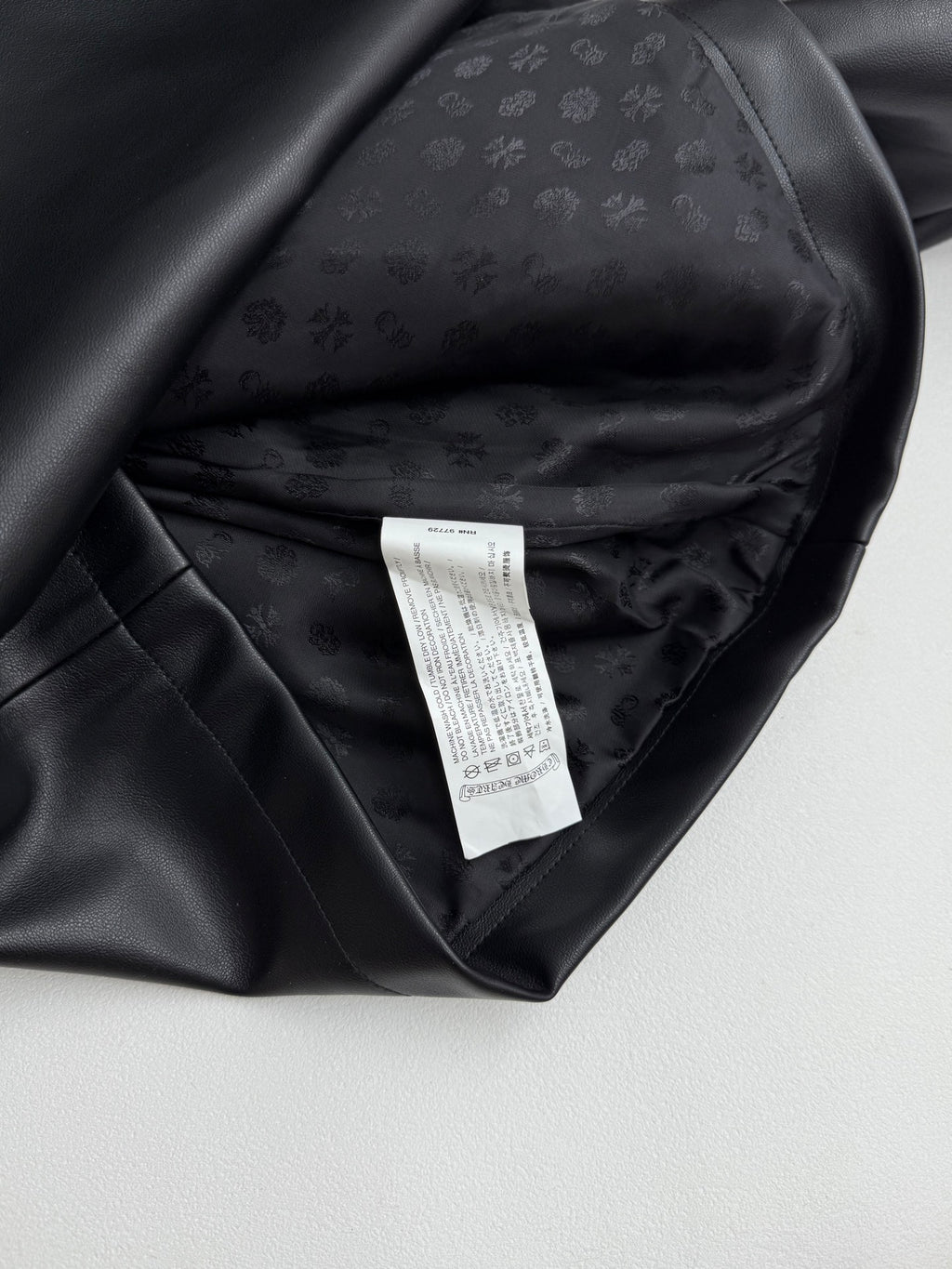 Black leather-look jacket interior with care label and inner lining