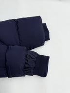 Navy puffer jacket cuffs with elastic ribbing and gathered strap details