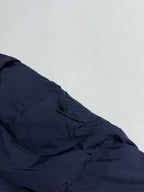 Navy puffer sleeve with stitched seam lines and small logo patch