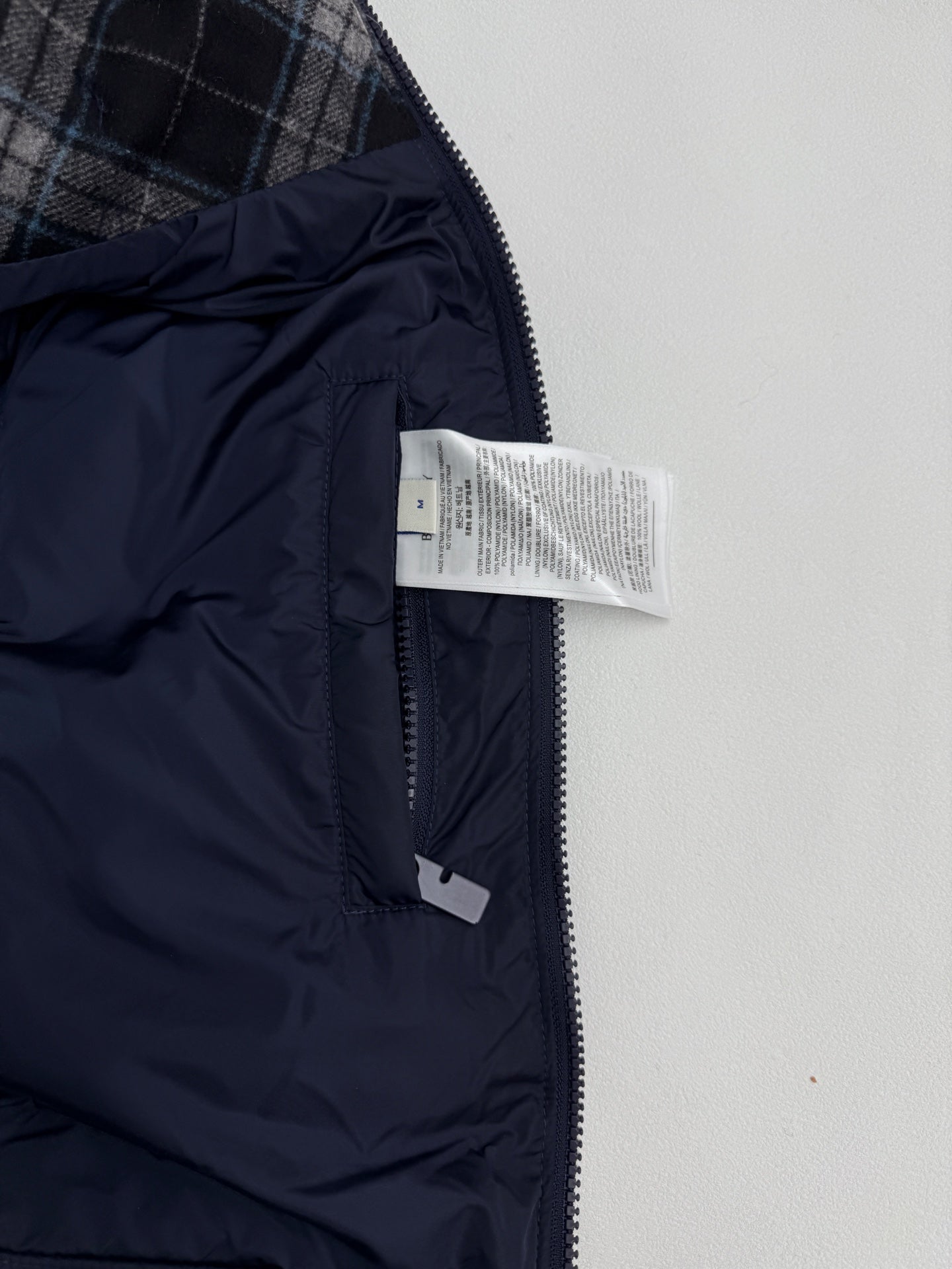 Long dark puffer coat with full zipper and visible interior label
