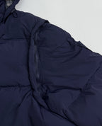 Navy quilted puffer jacket close-up of zipper and padded shoulder seam