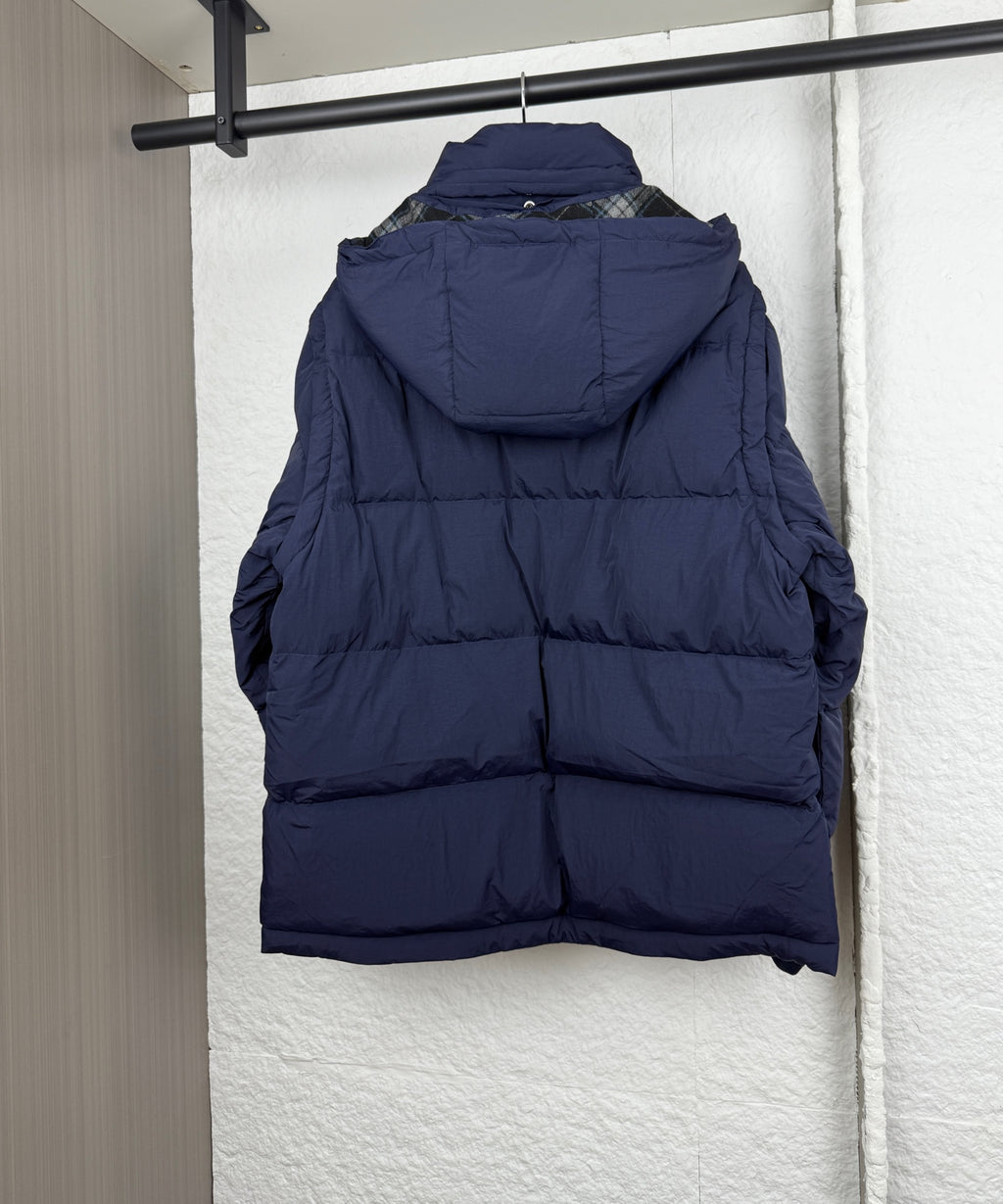 Navy hooded puffer jacket, back view with attached hood and quilted panels