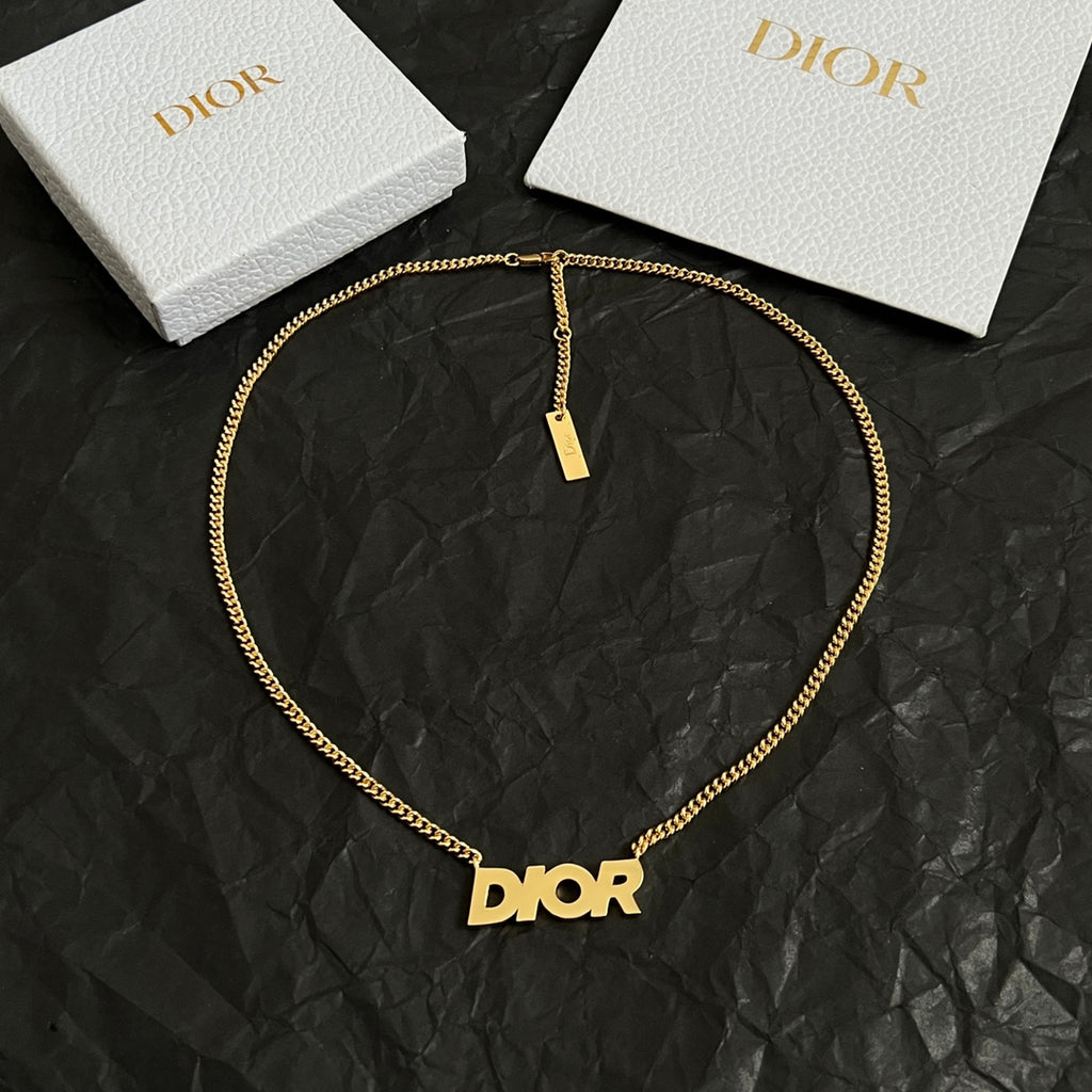 Gold-tone Dior necklace with Dior pendant and small rectangular charm tag.