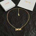 Gold-tone Dior necklace with Dior pendant and small rectangular charm tag.